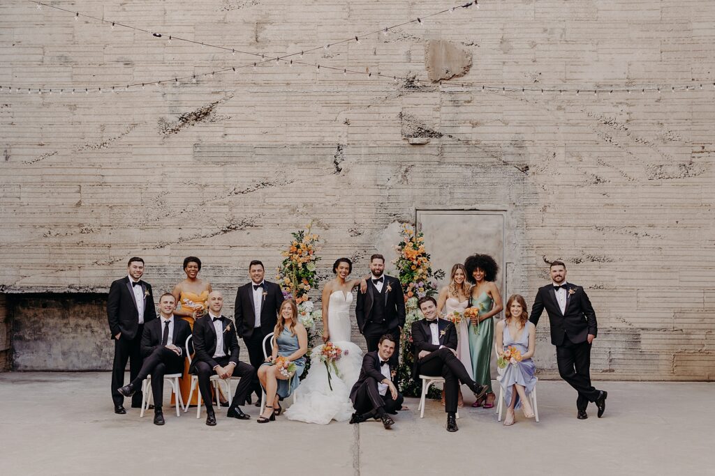 wedding party posed in editorial styled against brick wall