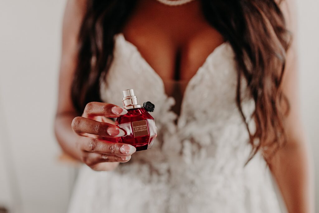 bride putting on perfume and jewelry on her wedding day.