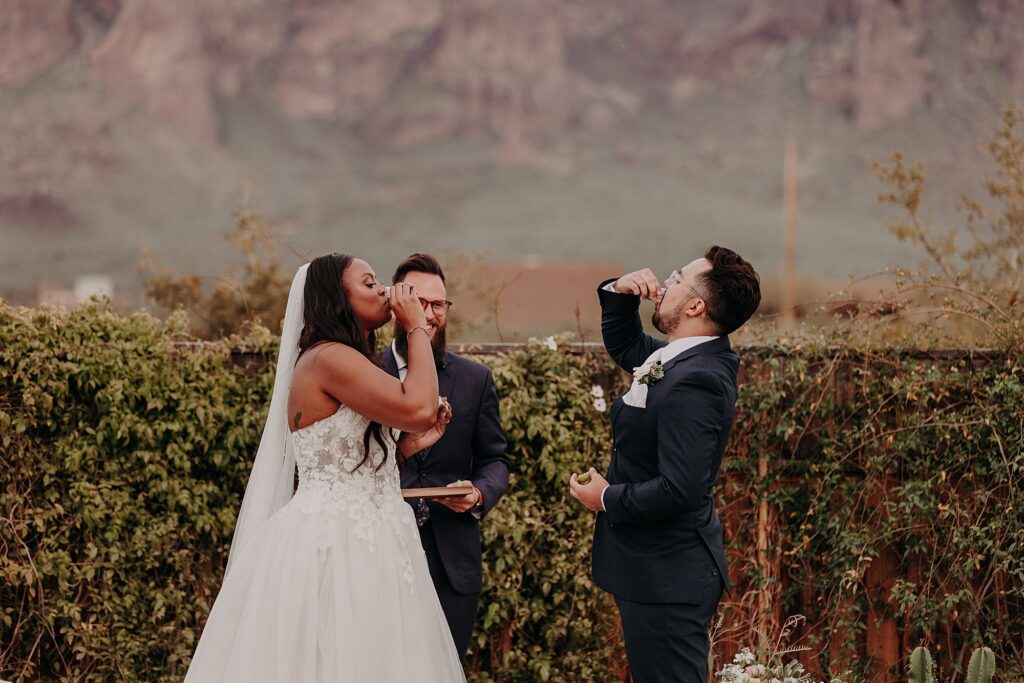 bride and groom taking shots together during their wedding ceremony