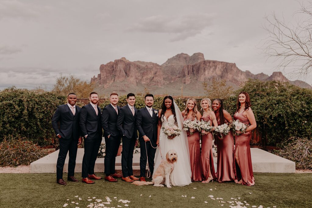 wedding party pose in front of the Superstition Mountains at sunset
