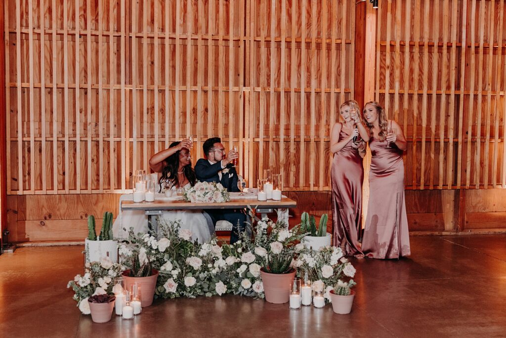 two bridesmaids give toast to bride and groom