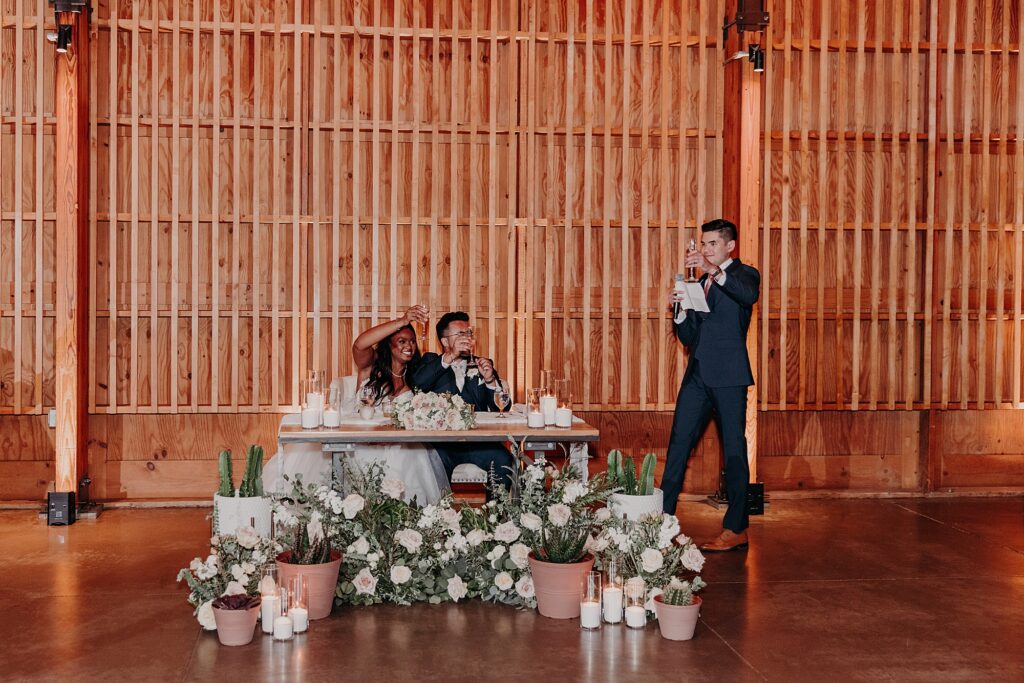 groomsmen gives toast at wedding to bride and groom