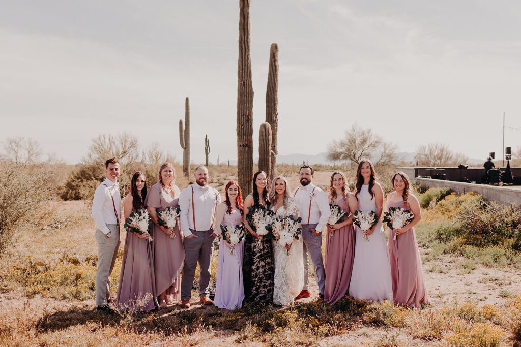 wedding party pose in front of cactus in the desert