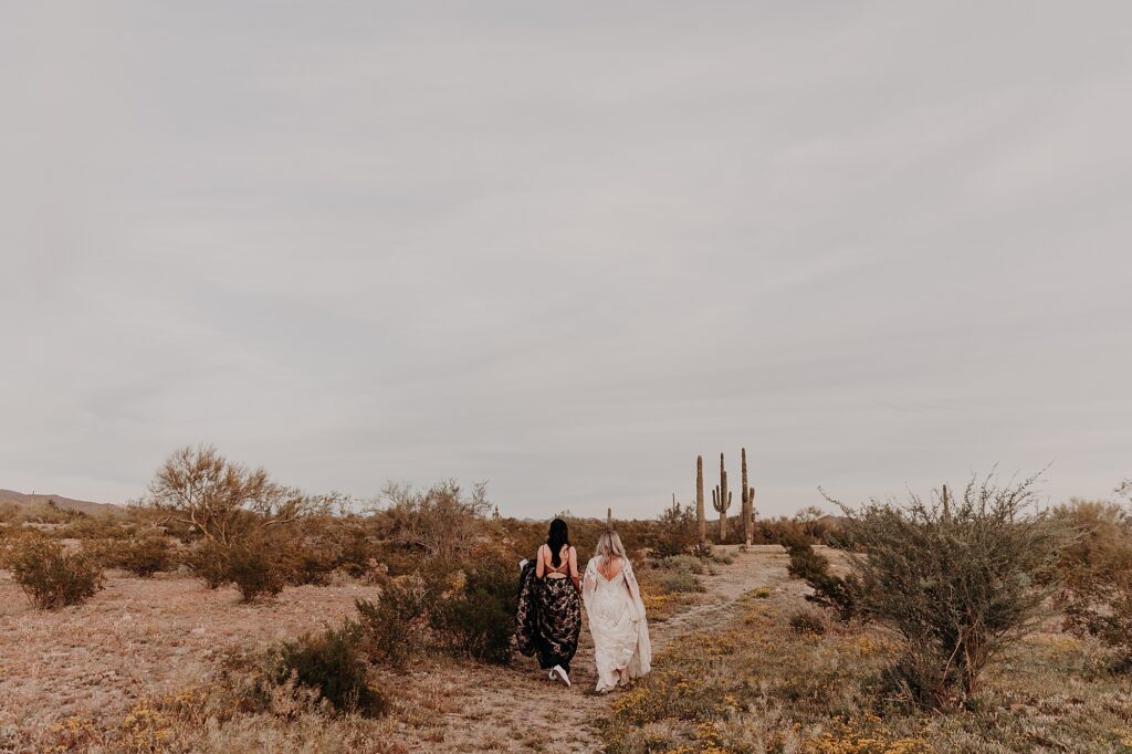 two brides walk in the desert together