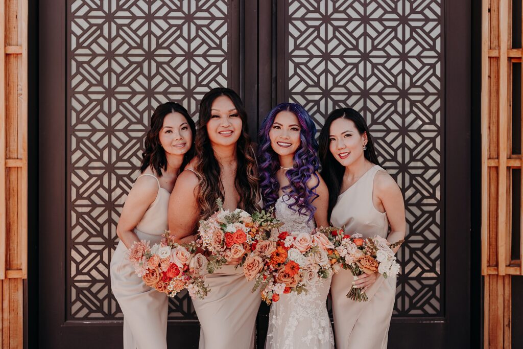 bridesmaids smile in front of mosaic designed door