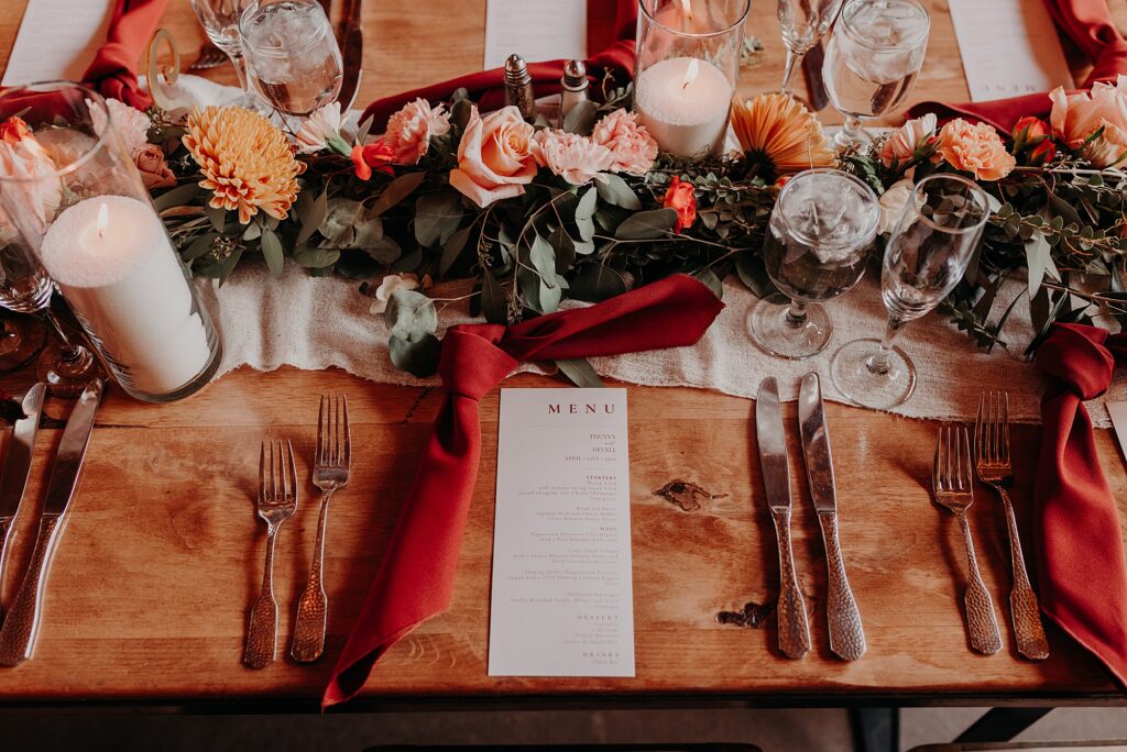 tablescape at wedding reception with burnt orange napkins