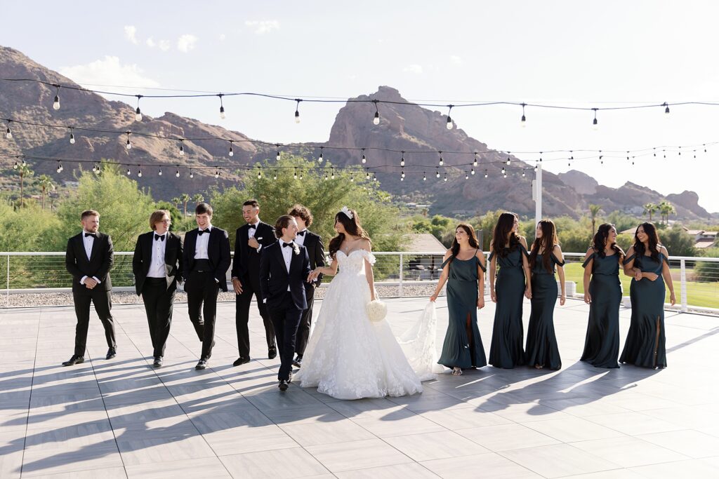 candid photo of wedding party walking and smiling at mountain shadows