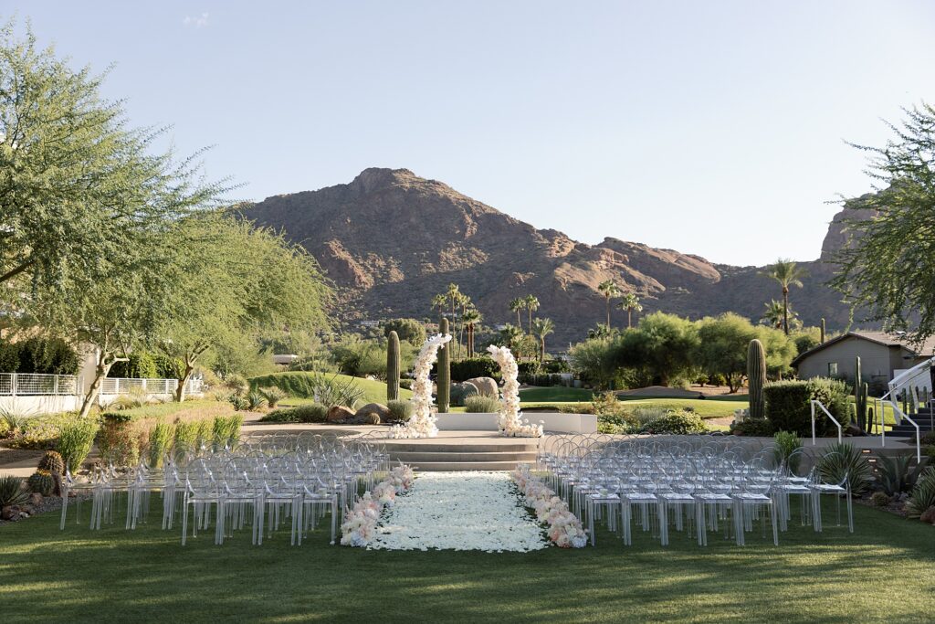 ceremony details with ghost chairs and neutral flowers at mountain shadows