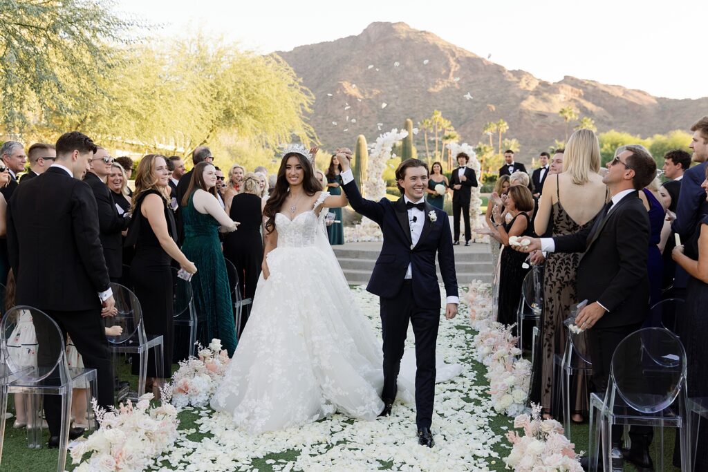 bride and groom walk down the aisle with a petal toss