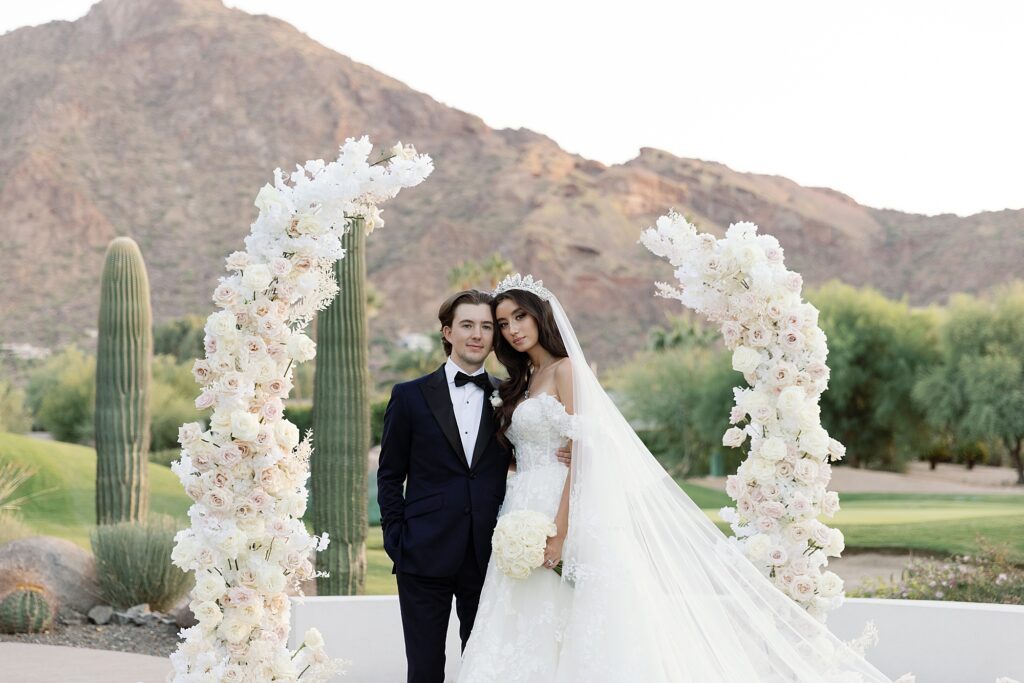 bride and groom cuddle and smile at the camera