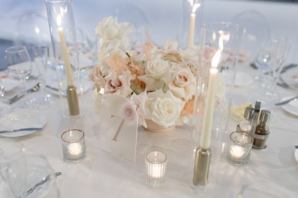 wedding reception table decorated with white roses and candles