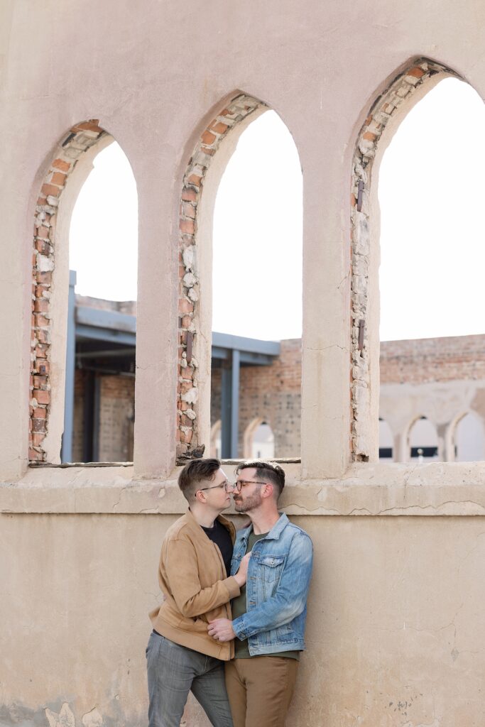 Portrait session at the Monroe Street Abbey under stone arches with LGBTQAI+ couple.