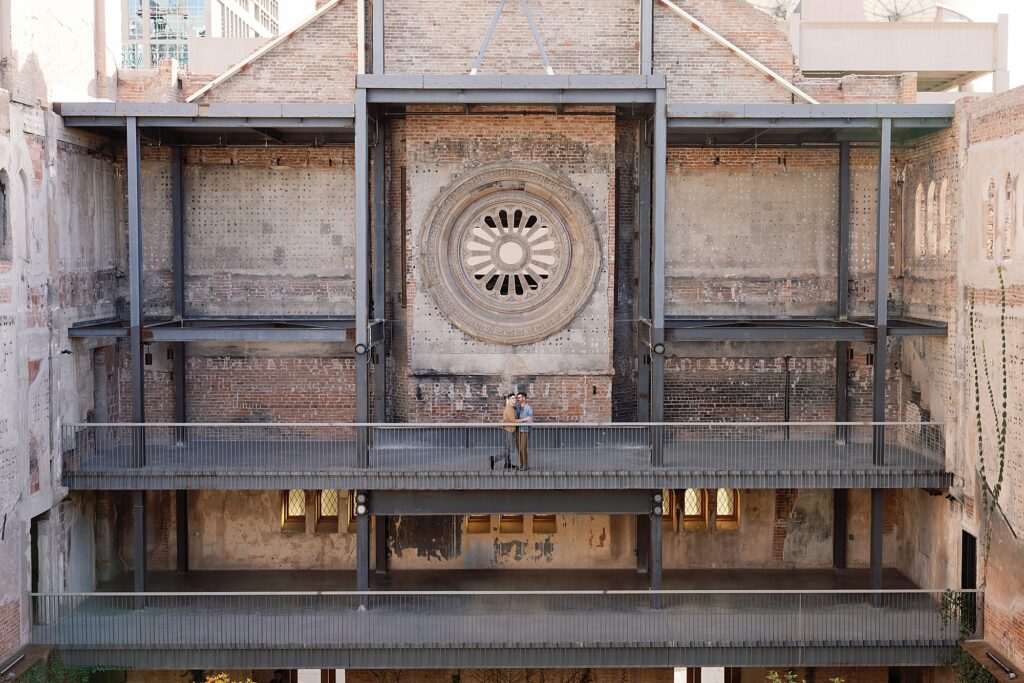 Couple stands in vast open air courtyard at Monroe Street Abbey wedding venue.