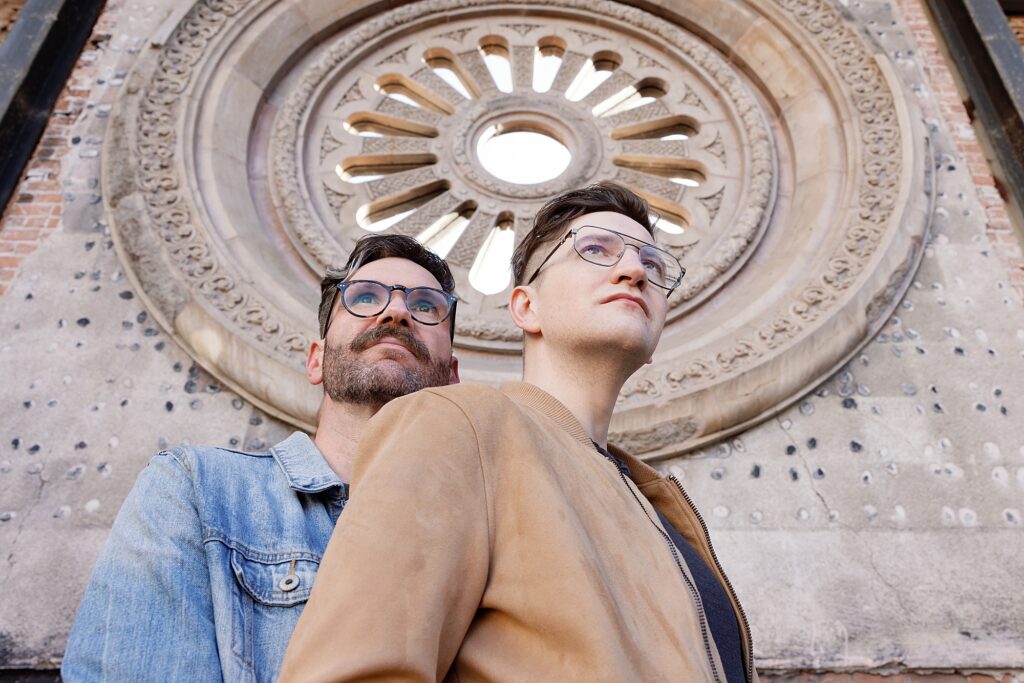 Couple cuddles in front of historic architecture at Monroe Street Abbey in central Phoenix.