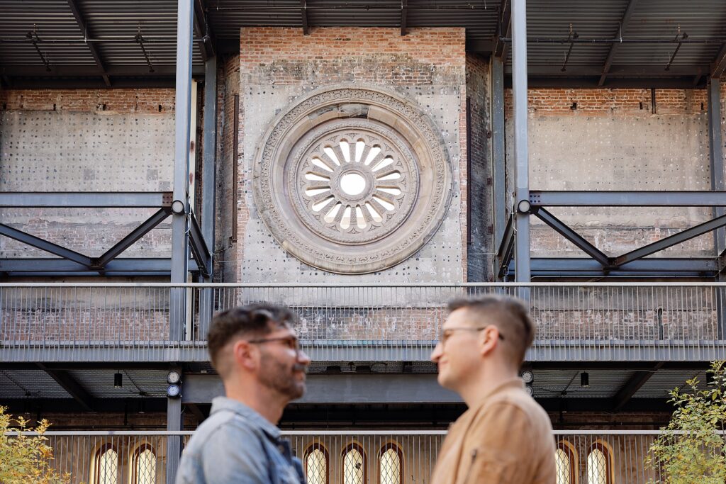 Couple cuddles in ivy covered open-air courtyard at the Monroe Street Abbey.