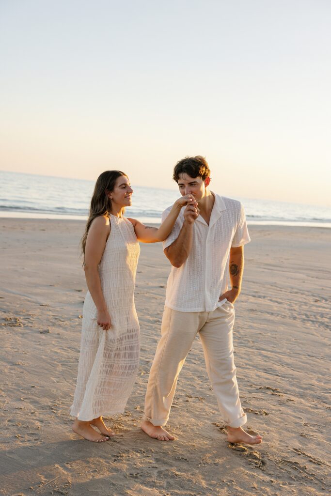 couple walk together on the beach at sunset