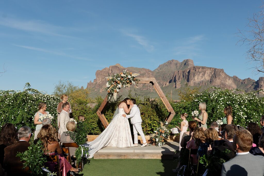Two brides share first kiss during wedding ceremony at the paseo.