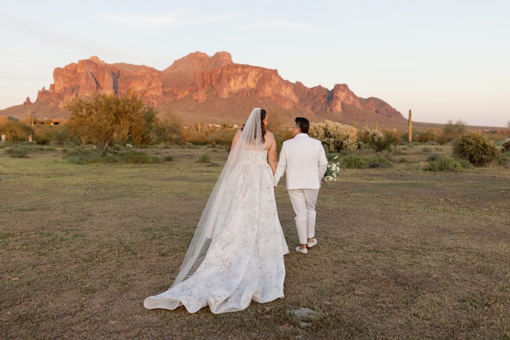Wedding couple walk in the desert at sunset at the paseo wedding venue.