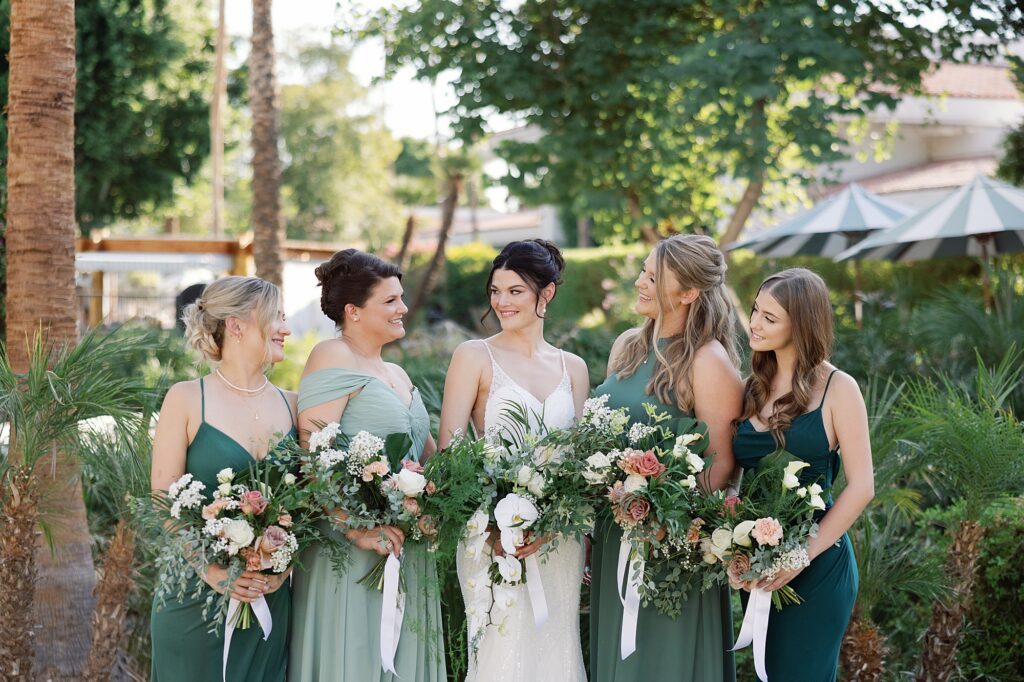 Bride and bridesmaids smile at one another while holding tropical bouquets at the Scott Resort and Spa.