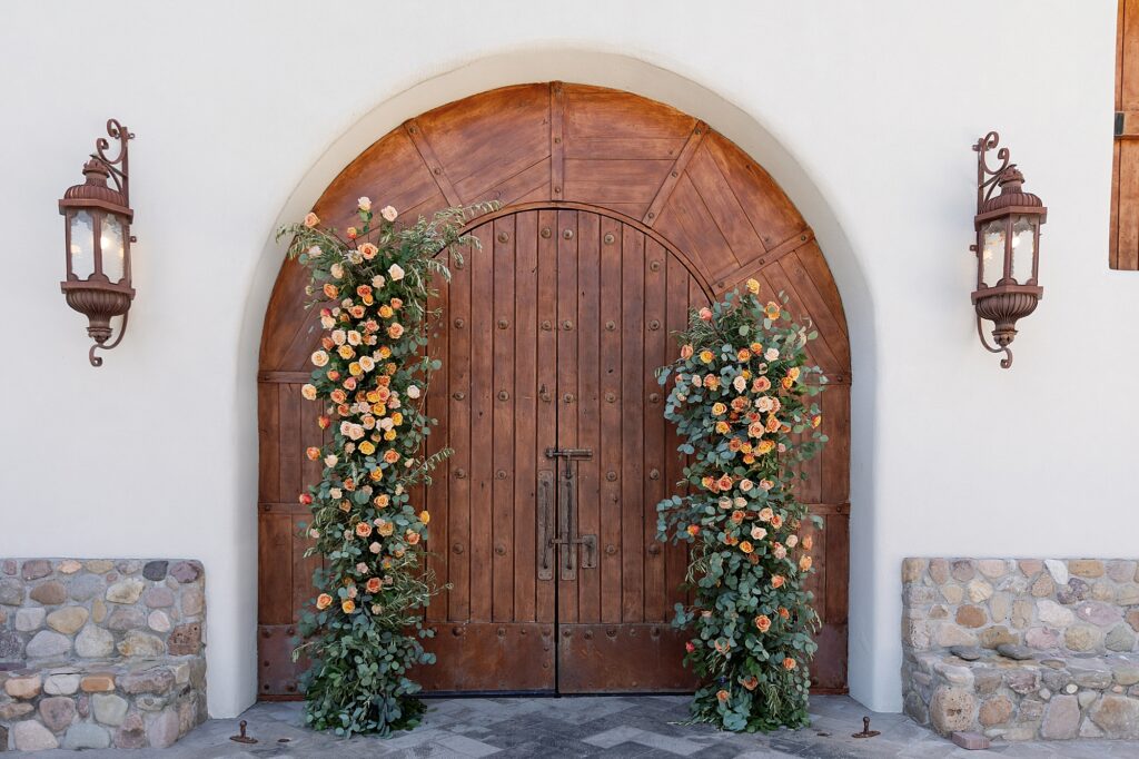 Wedding ceremony floral archway with orange roses and green eucalyptus at Tubac Resort and Spa. 