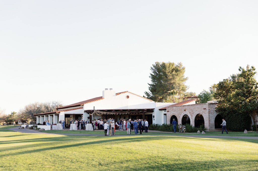 Wedding guests enjoy cocktail hour on green lawn at Tubac Resort and Spa.