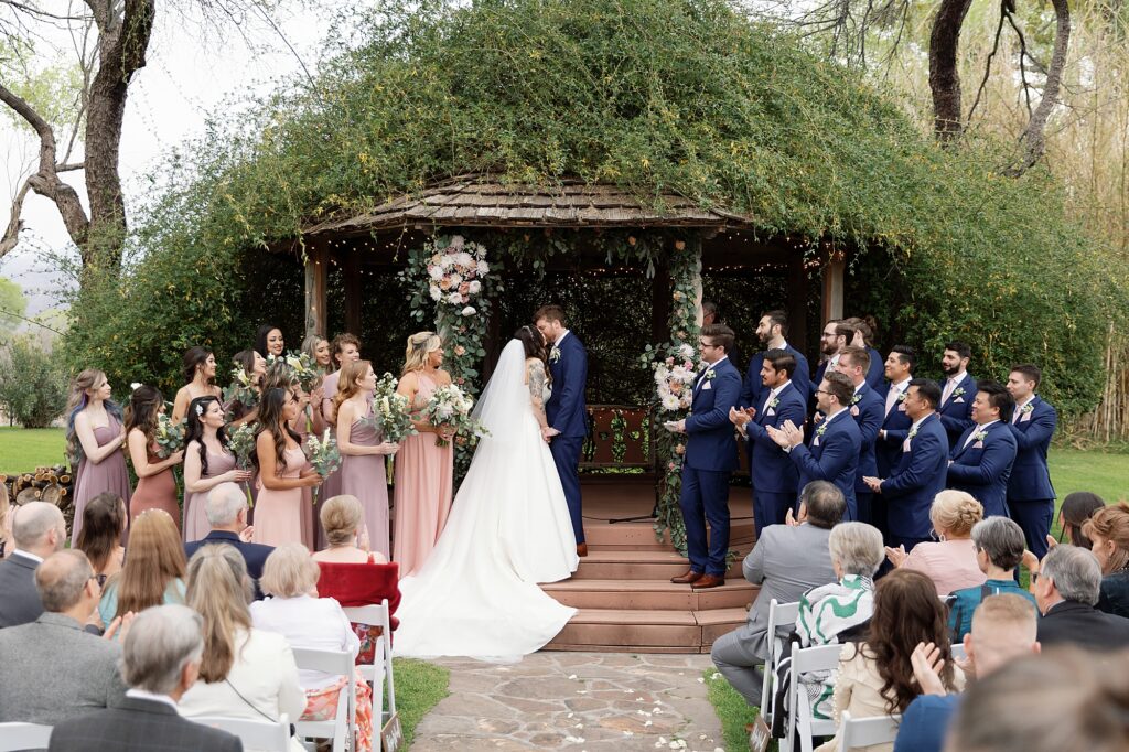 first kiss at wedding ceremony on a cloudy day