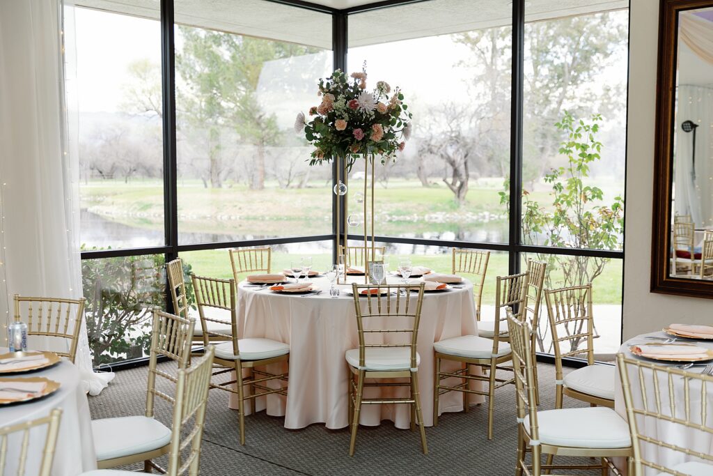 wedding reception table with gold chairs and neutral linens