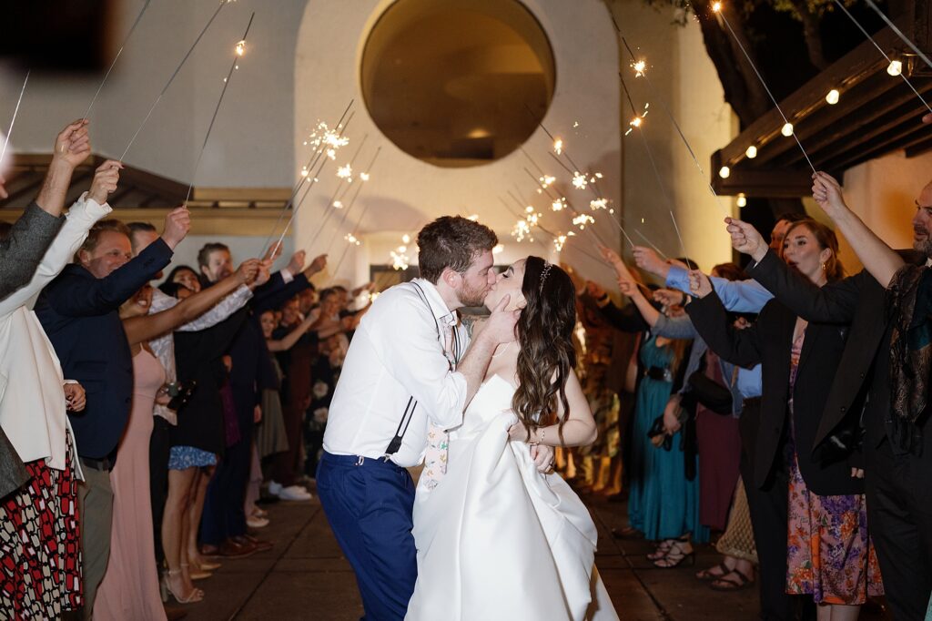 bride and groom kiss during sparkler exit