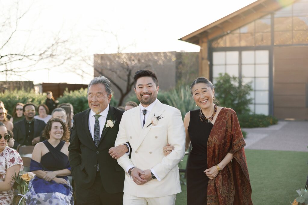 groom walking down the aisle as wedding ceremony begins