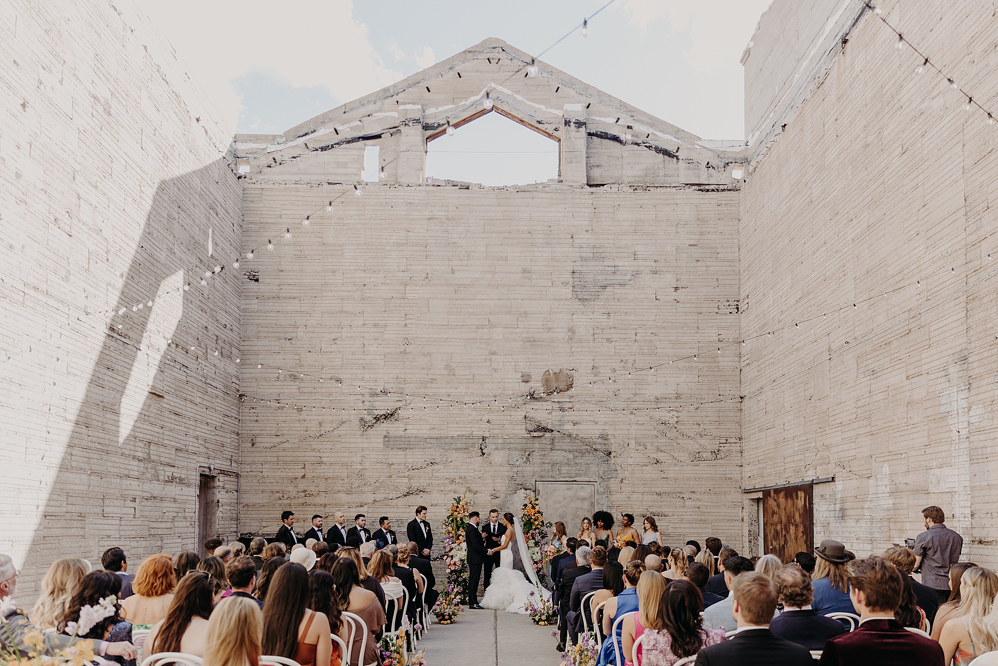 wedding ceremony in industrial space with colorful florals