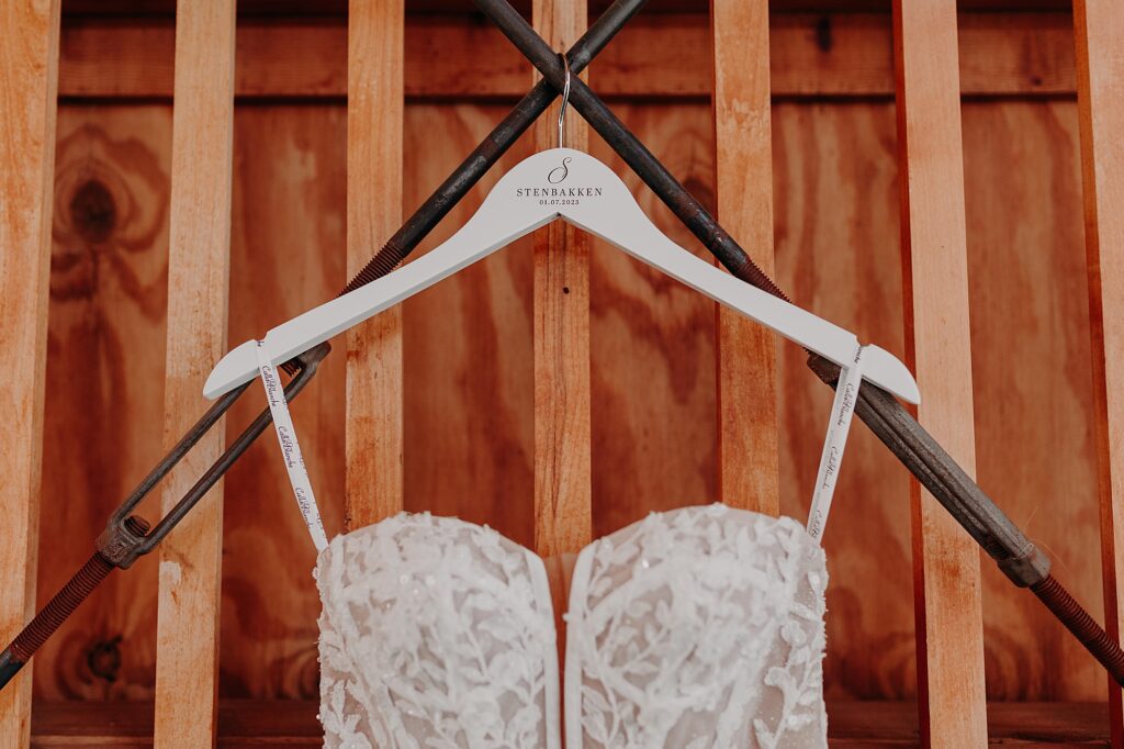 wedding dress hung up with custom hanger