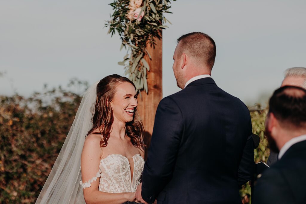 bride laughs at groom during ceremony