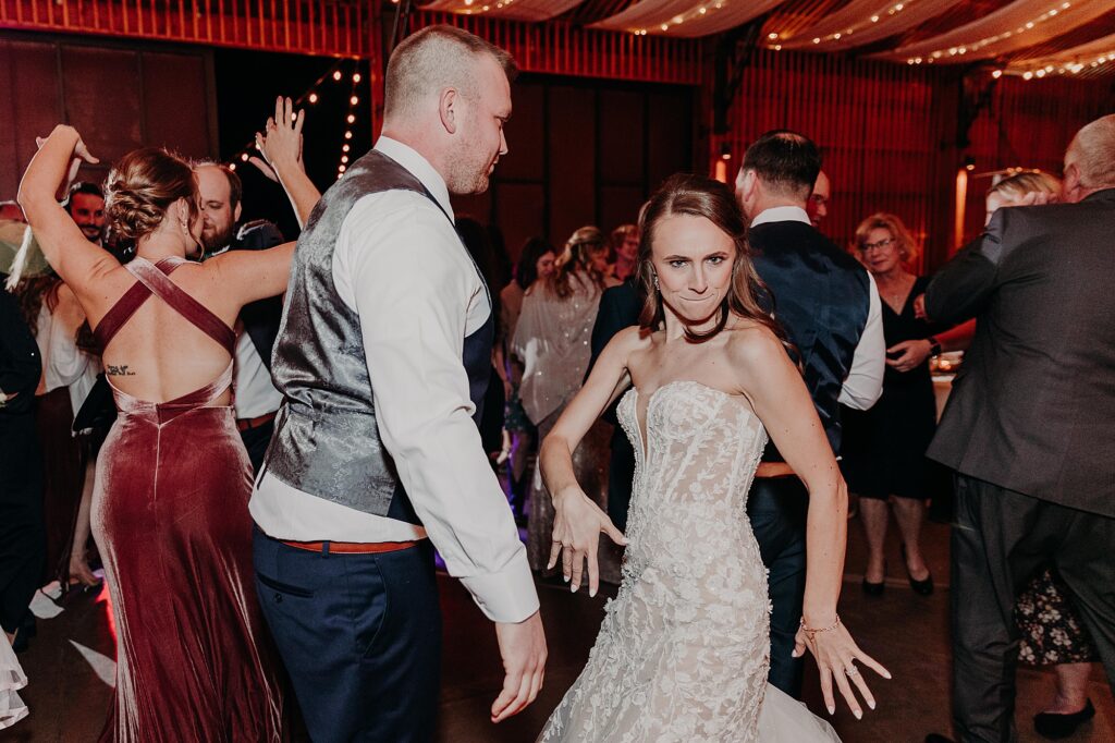 bride and groom share fun dance moves during wedding reception