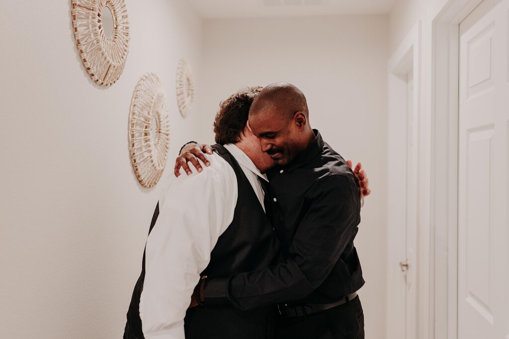 Groom and groom's dad hugging on wedding day