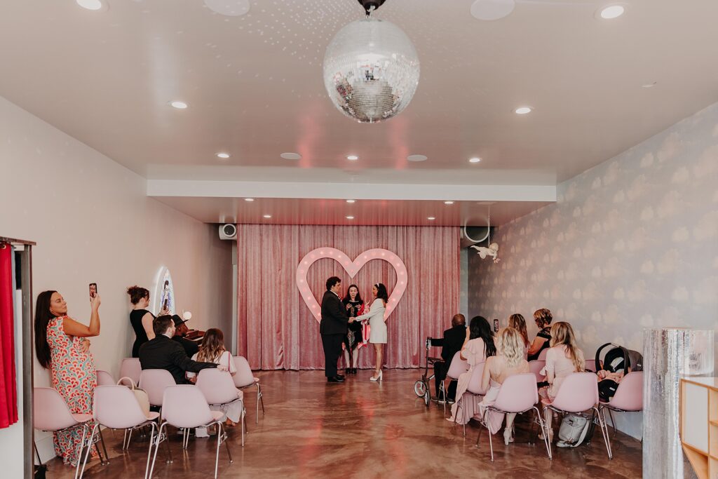 Wedding with pink heart backdrop at sure thing chapel