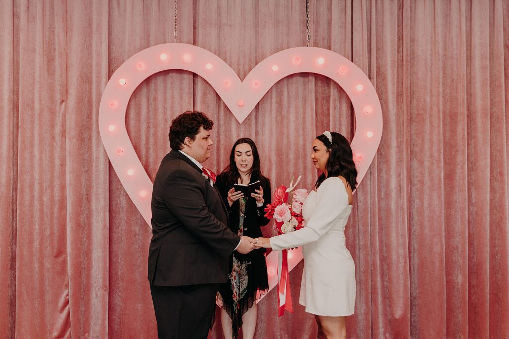 Wedding with pink heart backdrop at sure thing chapel