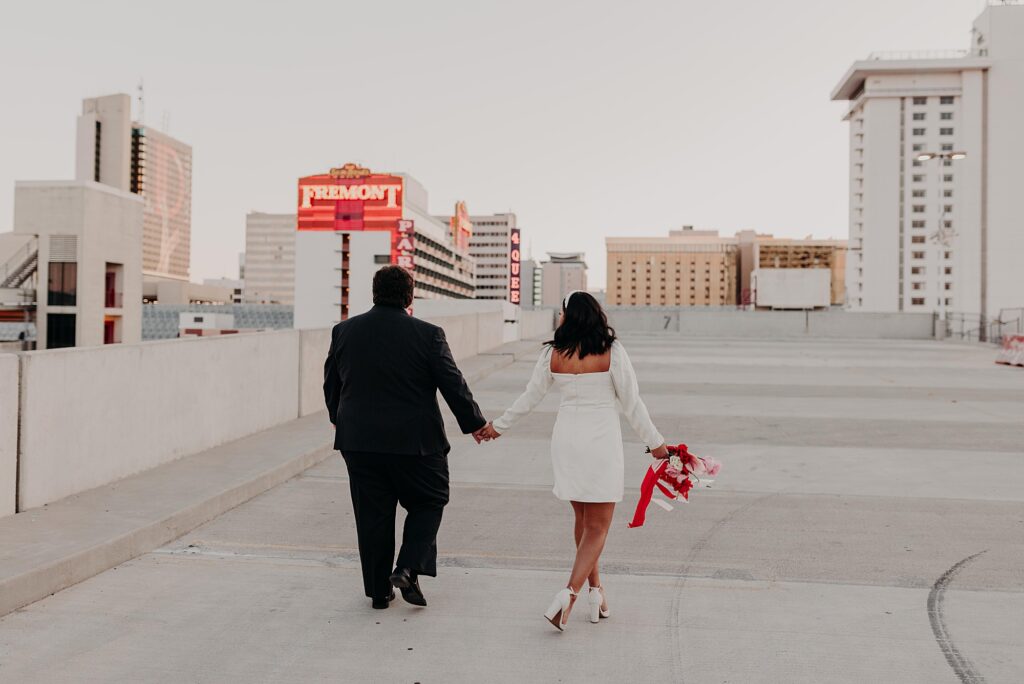 wedding couple walks on rooftop at Fremont street in vegas